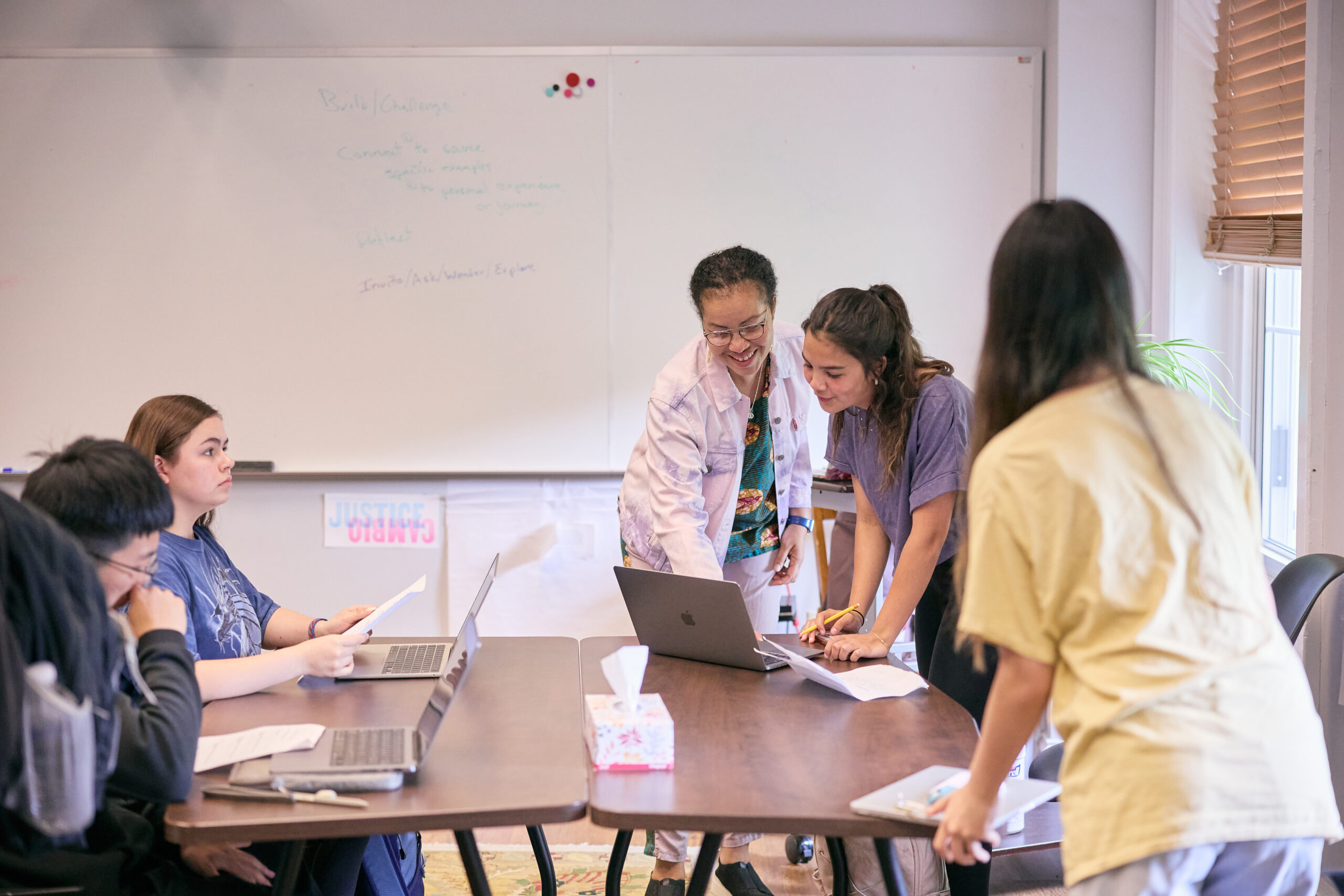 Teacher helping students on a computer